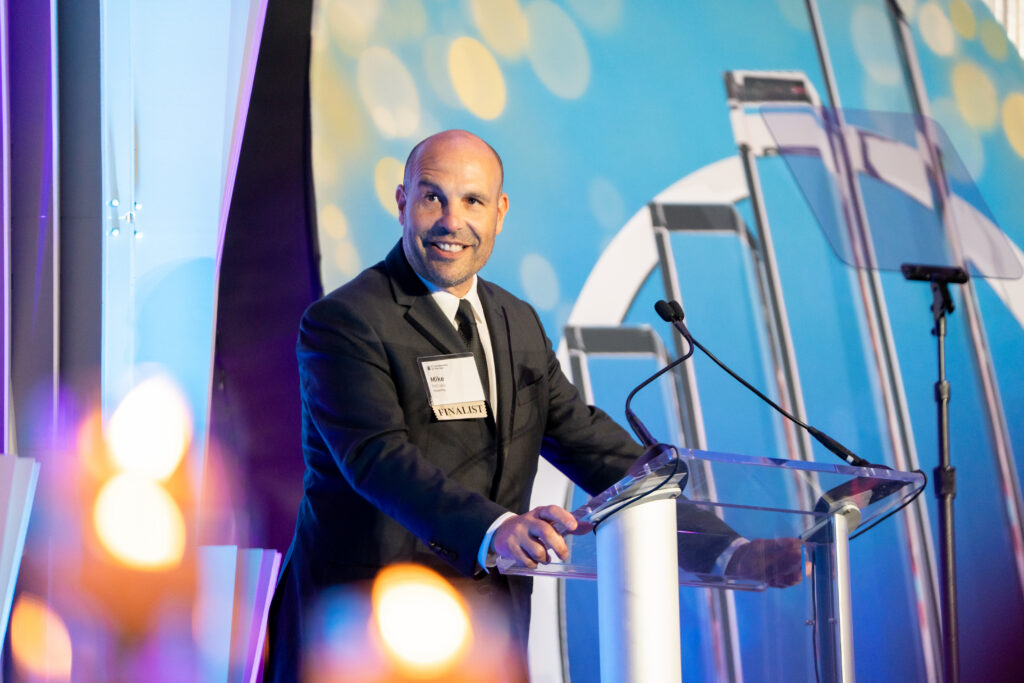 Photo of Mike Petrakis at the podium accepting EY Entrepreneur of the Year 2026